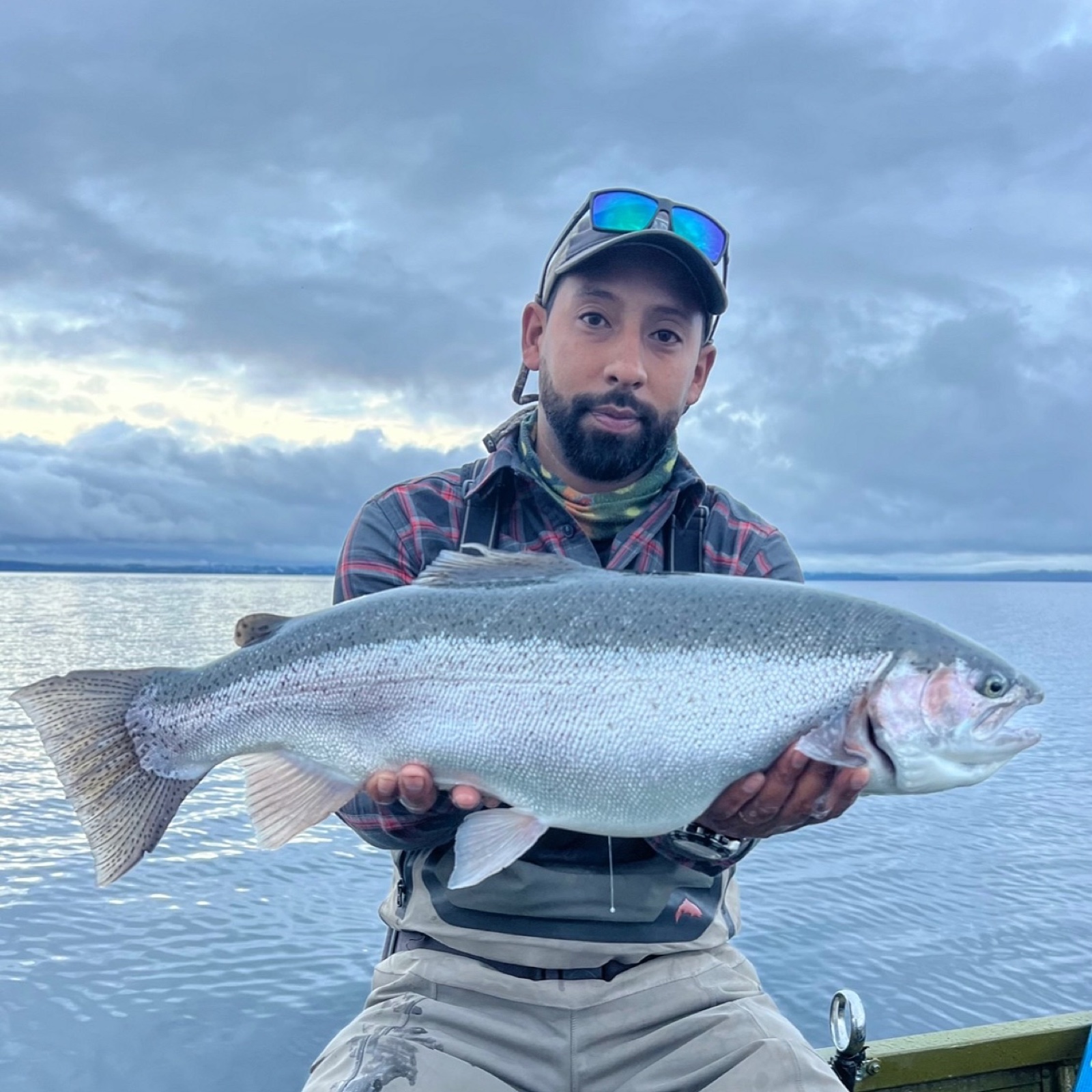 Marcos Quiroz holding a rainbow trout on a lake in southern Chile
