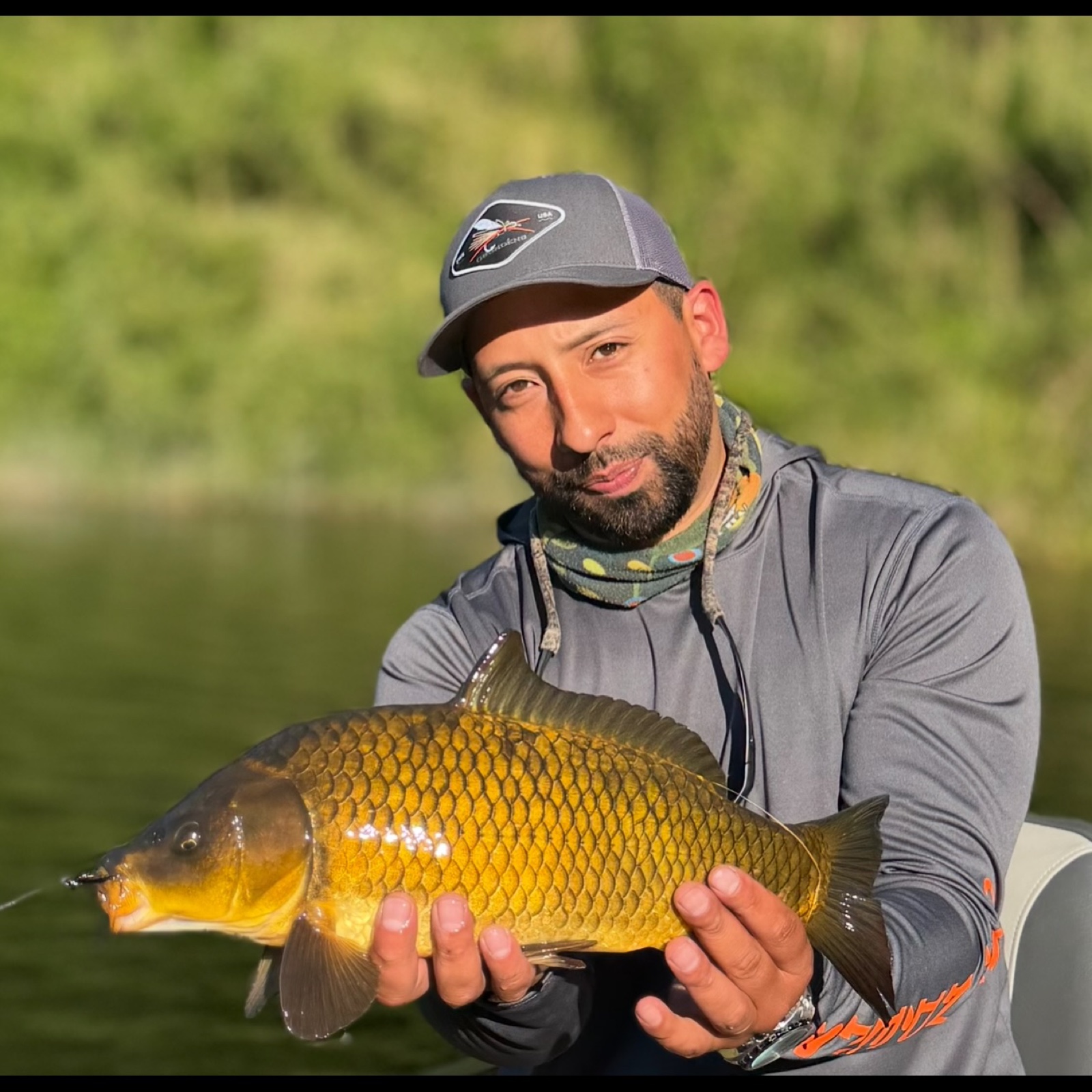 Marcos Quiroz holding a mirror carp caught on fly