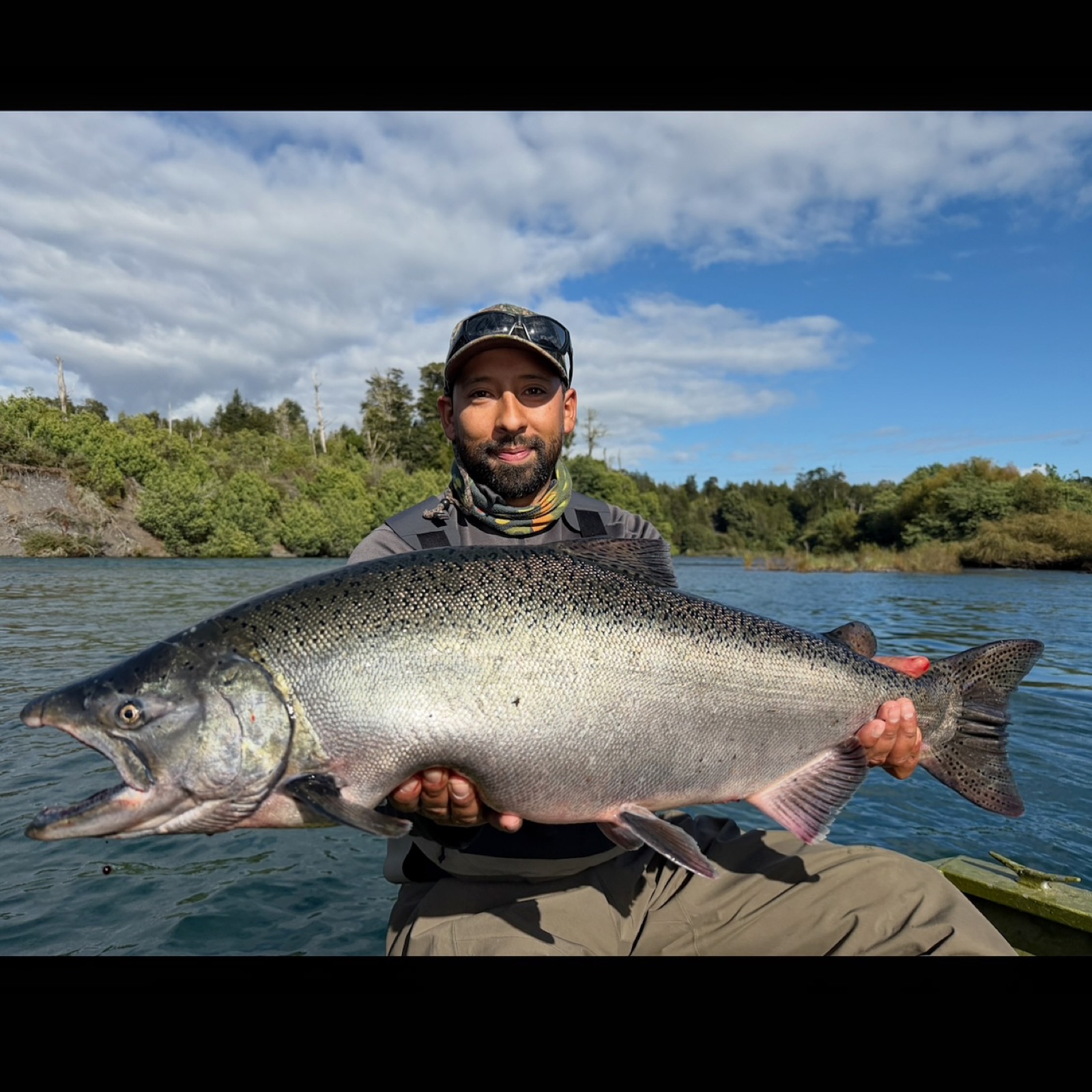 Marcos Quiroz holding a Chinook salmon on a guided fishing day