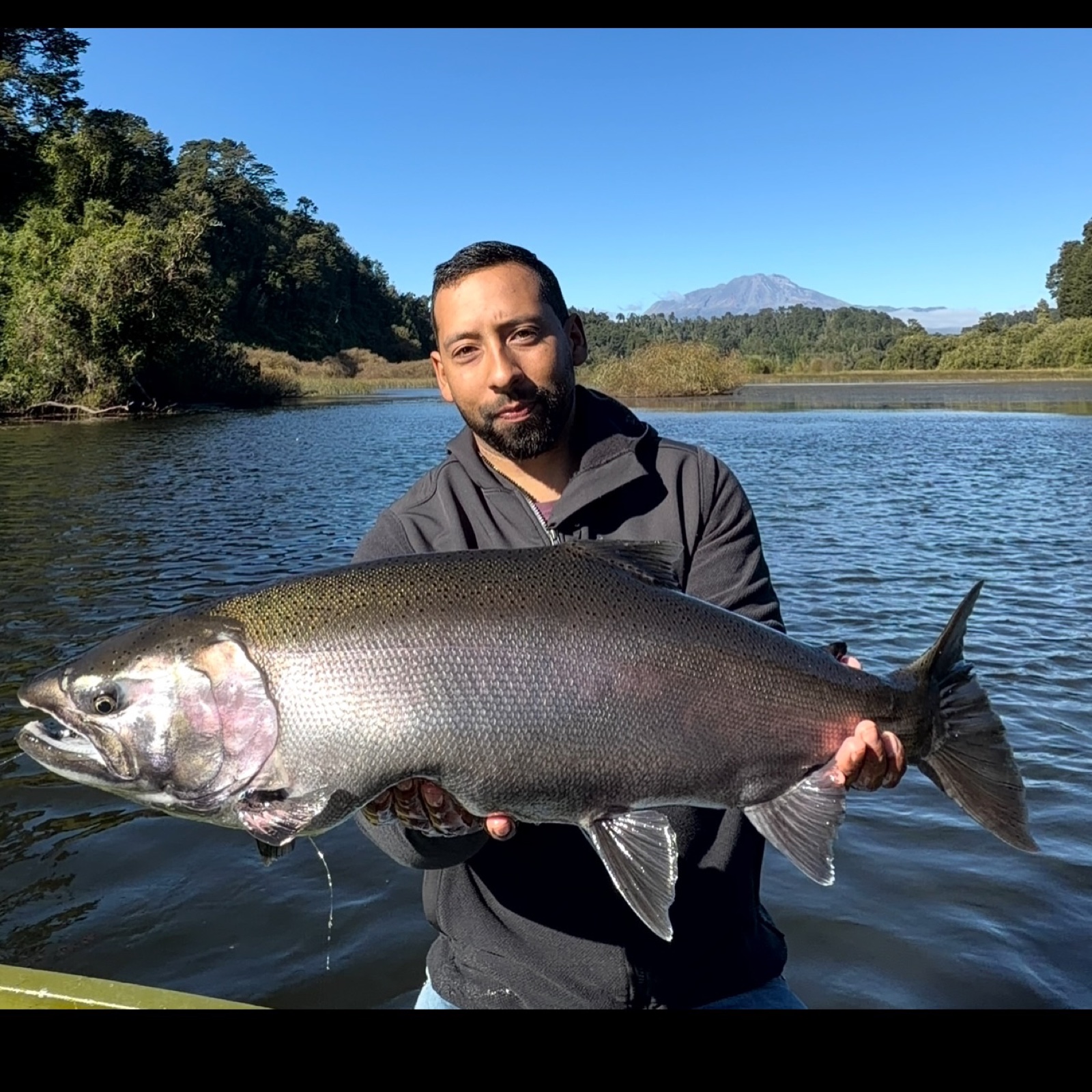Marcos Quiroz holding a Coho salmon near Puerto Varas
