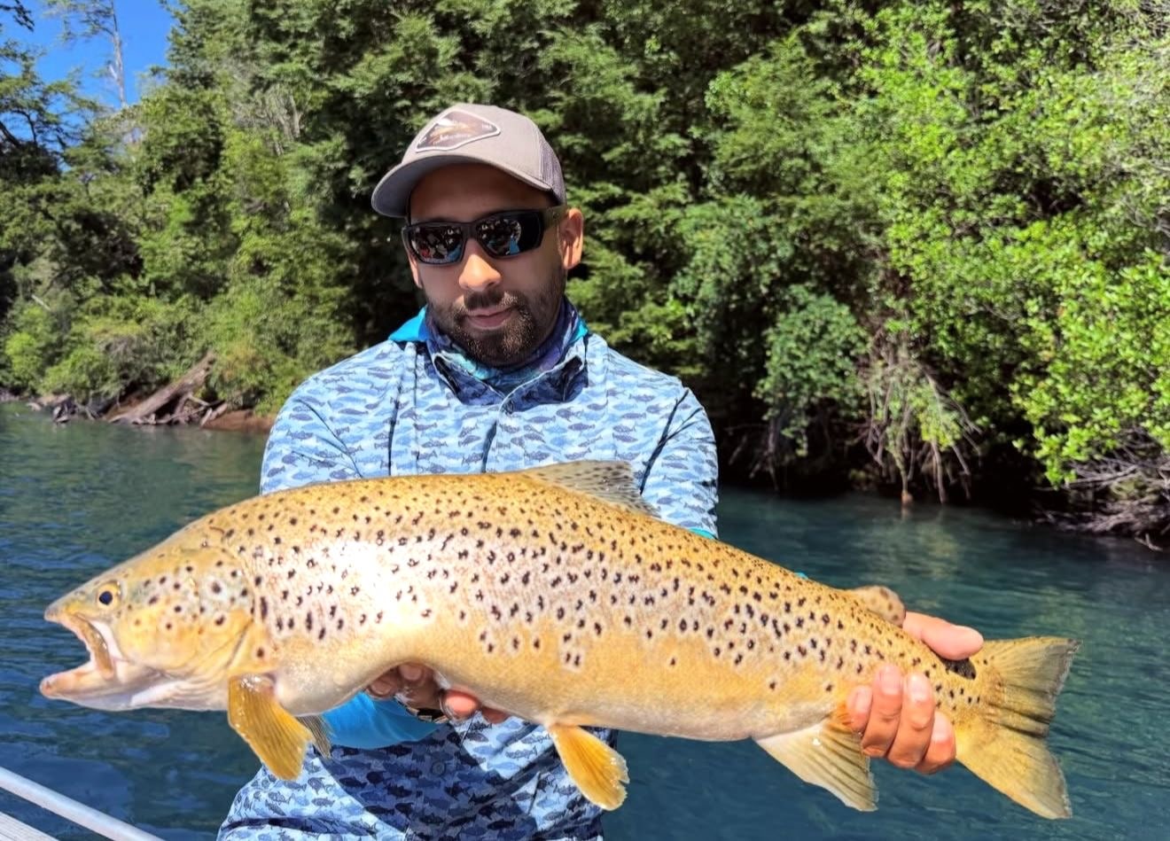 Angler holding a large southern trout in clear Lake District water
